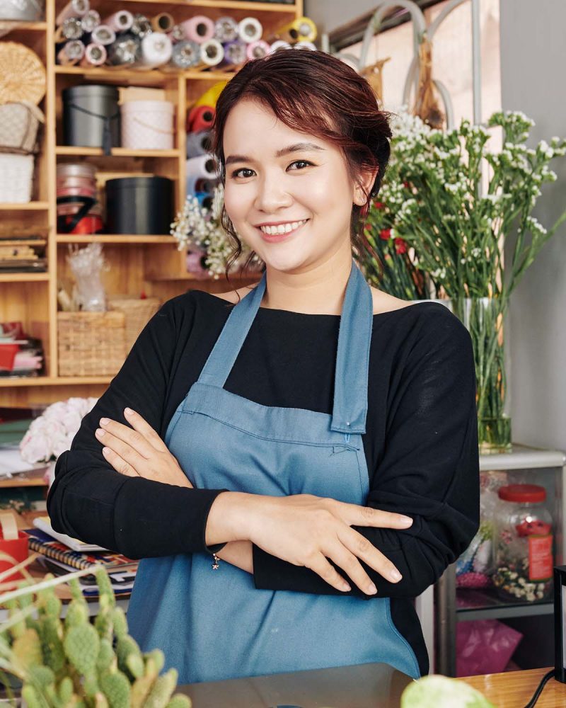 smiling-florist-at-flower-shop-counter-LJWKKET.jpg